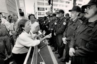 This flower has no power, Stoney-faced police remain unmoved as a protester offers them a flower at yesterday's demonstration at the intersection of U(...)