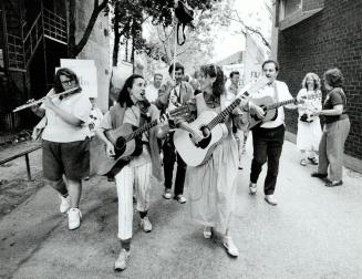 Reclaiming turf: Carrying protest signs and accompanied by musicians and clowns, demonstrators march through the Alexandra Park housing complex yesterday