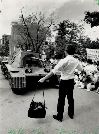 Heroism re-enacted: A demonstrator stands before a replica of a tank yesterday in front of the Chinese consulate, celebrating the heroism of a man last year in Beijing
