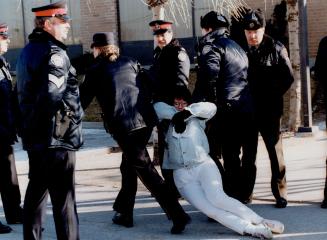 Against Violence: A protester is dragged away by Metro police during yesterday's demonstration at a Litton Systems plant to mark Internationl Women's Day