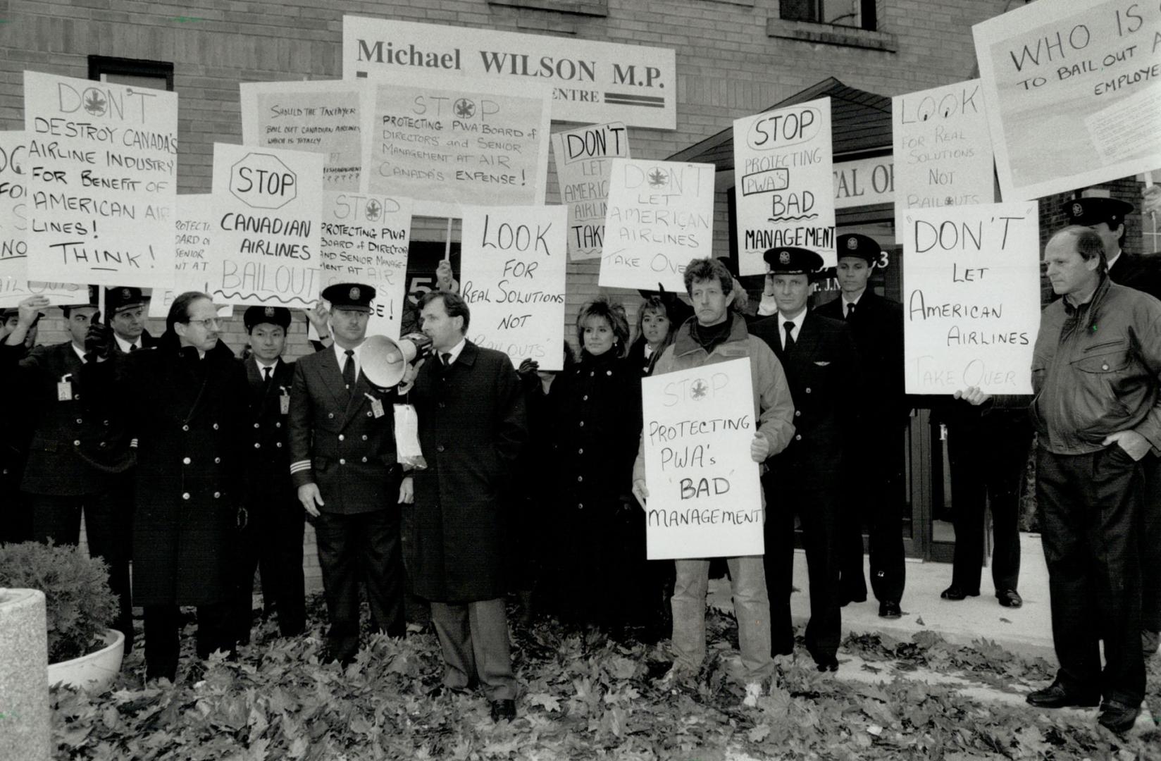 Placard protest: Air Canada pilot Ed Godin, with loudhailer, talks to fellow workers protesting aid for Canadian Airlines at Trade Minister Michael Wilson's constituency office in Toronto yesterday