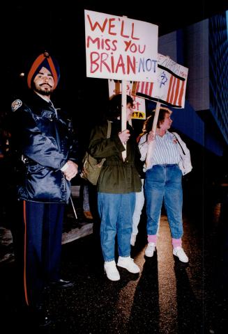 A Metro police officer stands watch as demonstrators protest last night outside the Constellation Hotel where Prime Minister Brian Mulroney addressed a Conservative dinner