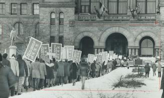 Teachers carry placards outside Queen's Park as they protest the proposed legislation nullifying their resignations
