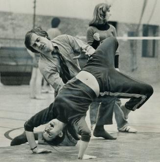 With teachers gone, principal Ian McHaffie instructs 15-year-old Sandra Barkwell in gymnastics yesterday in Dr. G. W. Williams Secondary School in Aurora. [Incomplete]