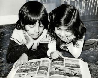 Children of salesman Rafiq Ahmed look at the family encyclopedia in their Mississauga home