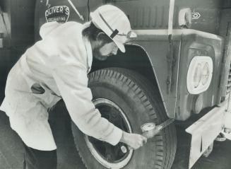 A technician checks the outside of a truck in Port Hope, Ont