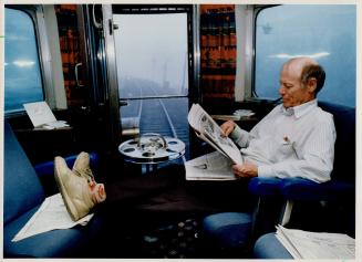 Rail Relaxation: Bob Macdonald of Burlington puts his feet up and settles down to read his newspaper as VIA Rail's Transcontinental train rolls through Muskoka