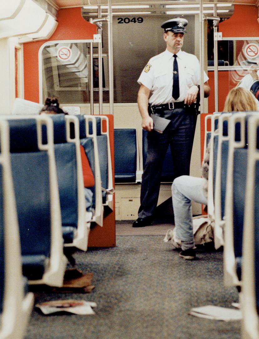 Keeping watch: A security guard joins passengers on the Oakville-to-Toronto GO train last night after a sex assault on a train Tuesday