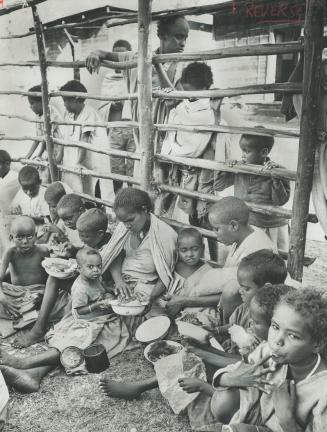 At meal time in a camp near Dessie, Ethiopia, mothers and children sit in a large enclosure to be fed