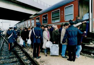 Freedom Train: Scores of Albanian refugees, wearing and carrying donated clothing, leave the port of Brindisi for other parts of Italy