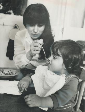 Mrs. Beatriz Droguett feeds her son Boris, 18 months, during lunch at Ontario's Welcome House (York and Lakeshore). The House takes care of children o(...)