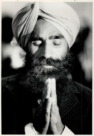 Thankful arrival: A Sikh prays in a Metro yesterday after his trip from Halifax