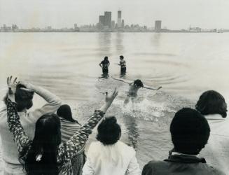 A Jesus people convert with hands outstretched returns to shore on the Toronto Islands after being baptized in the harbor waters in September, 1971. T(...)