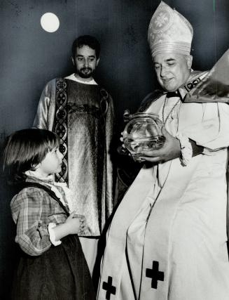 Bless you: Right Rev. Basil Tonks blesses 3-year-old Tara Aitken's goldfish - Chip and Dale - while at right a forlorn-looking-boxer sits quietly with(...)