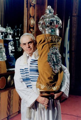 Sexton David Beck holds a richly decorated Torah scroll at the Beth Sholom synagogue on Eglinton Ave