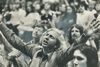 Ecstatic gesture of a worshipper at a Toronto Jesus Music Festival is typical of the new Revivalism