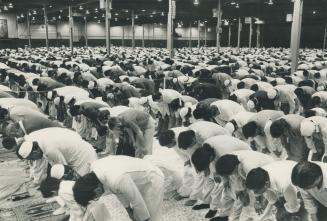 Original Toronto Star caption: Muslims celebrate end of Ramadan; Metro's Muslim community; which numbers over 100;000; celebrated Eid al-Fitr yesterday marking the end of the month of Ramadan; the holiest of Muslim celebrations. Religious ceremonies were held in several locations across Metro; including the International Centre in Mississauga; above; where thousands of the faithful bowed in prayer as part of the ancient tradition.