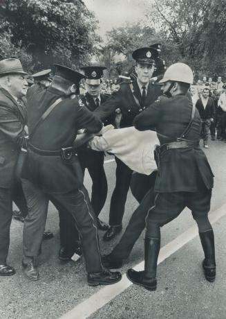 A Wild Struggle erupts as police try to protect self-styled Canadian Nazi Party leader William Beattie (white shirt) from a man who hurled himself thr(...)