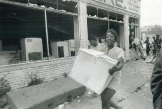 Shopping (Riot Style), this woman carts away the merchandise she picked up on a 'no cash, just carry' basis by stepping through shattered front window(...)