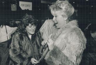 Palma Carusi (right) beams as she tries on a fur coat she bought for $75 at the Hadassah-Wizo Bazaar today