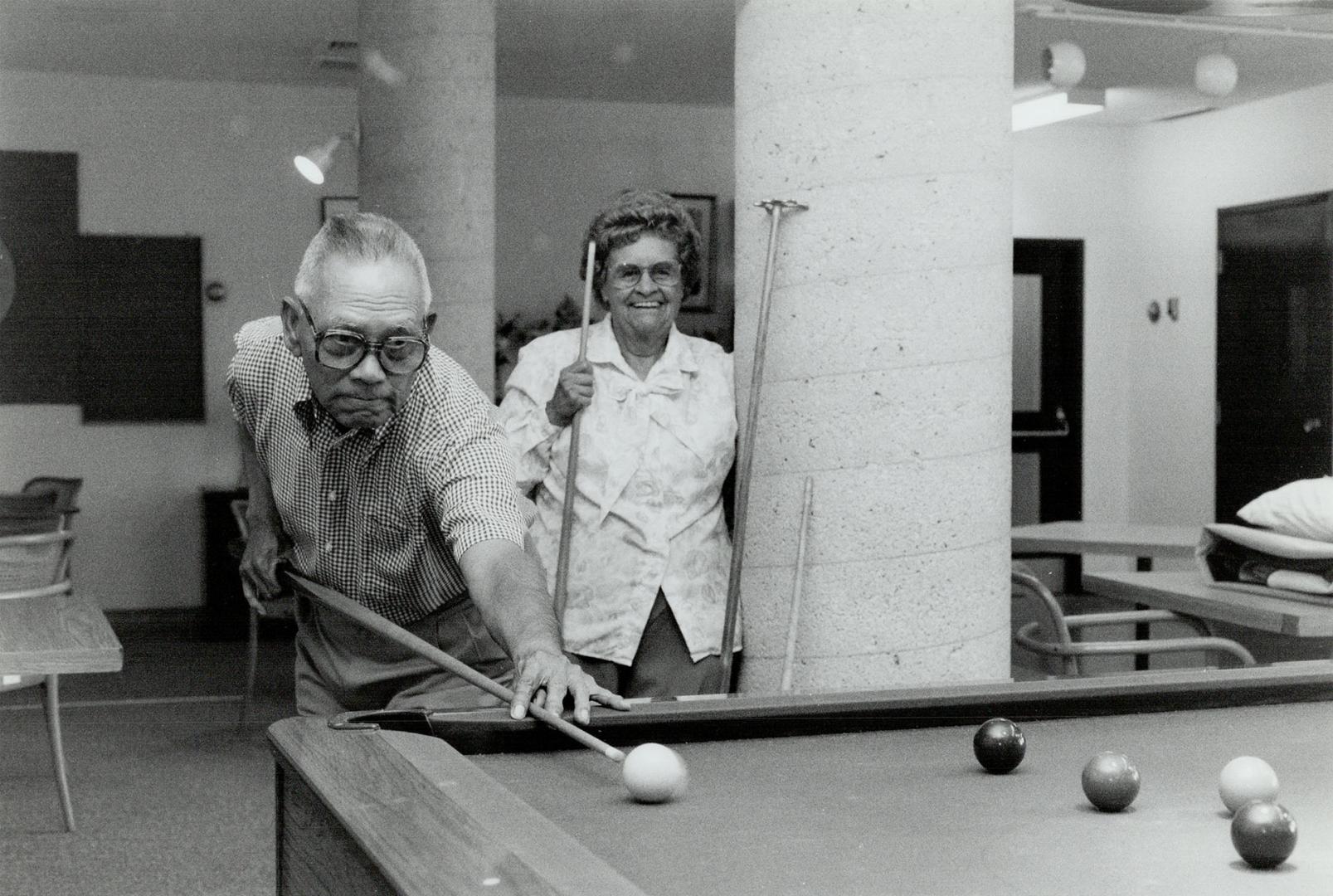 Senior snooker, Sergio Ruiz lines up a shot as Dorothy Hopkinson awaits her turn at St