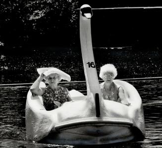 Full steam ahead, Mrs. Swan, Two seniors out at Centre Island yesterday sit back and relax while th swan takes them for a peaceful ride on what was an(...)