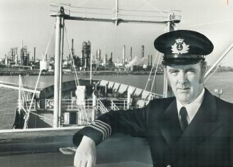 Capt. John McIntyre stands on the flying bridge of his oil tanker, the Gulf Canada, with the Gulf refinery and tank farm at Clarkson behind him, as th(...)