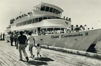 Passengers hurry to board the sparkling new Chief Commanda II, operated by the Ontario Northland Transportation Commission, for a cruise on Lake Nipis(...)