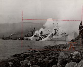 Beached on historic Siwash Rock where she was towed after six explosions ripped her hull and shook downtown Vancouver yesterday noon, the freighter Gr(...)