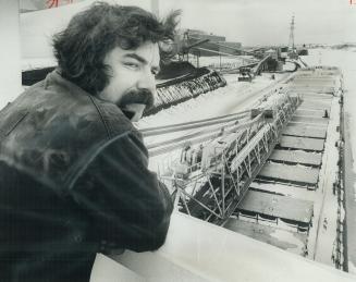 On His Lonely Vigil, shipkeeper Bill Peachie looks over the 730-foot Canadian Olympic, the new $33 million grain and coal carrier in her winter berth (...)