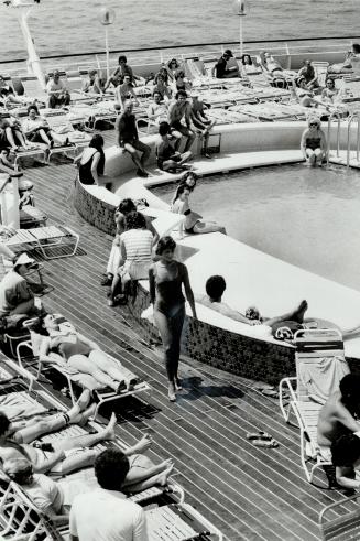A fashion show on the pool deck finds the young woman in foreground modelling swimwear