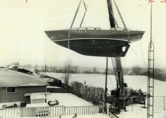 13-Ton Sailing Yacht is lifted by crane from the back garden of the Western family's home, in Bay Ridges, to be hauled by trailer to a marina at Frenc(...)