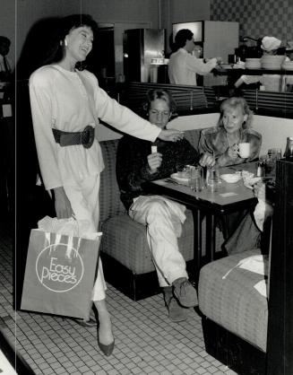 Restaurant runway: A Model from Five Easy Pieces winds her way around the tables wearing the latest at a Yorkdale restaurant, as shoppers Bernard Holzberg and Phyllis Chapnik watch