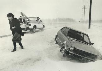 A tow truck comes to rescue Monique Laver and her ditched car on Sideroad 10, Brampton
