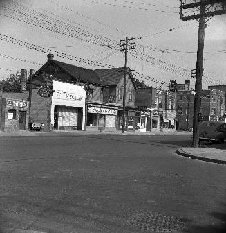 Store fronts and former Bedford Park Hotel, Yonge and Glenforest. Image shows a few stores. The ...