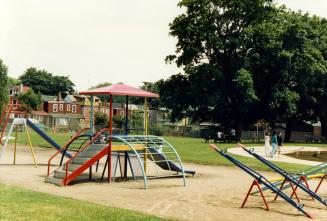 Image shows a playground with some trees in the background.