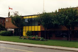 Image shows a two storey centre facing the street with a Canadian flag on the roof with some tr ...