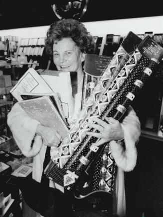 Jeanie Hersenhoren scoops up cut-price Christmas wrap as she joins Boxing Day bargain hunters at the Eaton Centre today