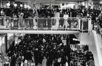 Bargain hunters: Thousands of shoppers jostle in the Eaton Centre yesterday to snap up Boxing Day bargains offered by stores