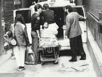 Woman collapsed: A female shopper, who collapsed in the crush of bargain hunters, is loaded by attendants into an ambulance in the rear lane behind the Fairweather clothing store