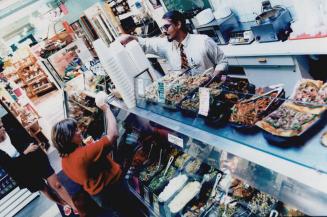 Lesley Garant serves a customer at the deli in the Big Carrot Natural Food Market