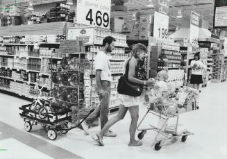 Jan Huffman offers 1-year-old Jamie a bottle as she and husband Terry shop at Loblaws on Leslie St