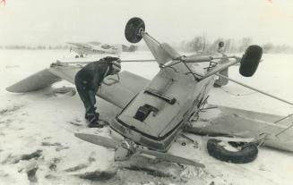 Claude Bimm of Rexdale checks one of three planes flipped by high winds at King City airport