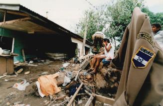 Open air family. Kid on bed. Taking a break from salvaging possessions Adolfo Miraldo sits on his parents bed. The family sleeps at the site to protect their things from looters