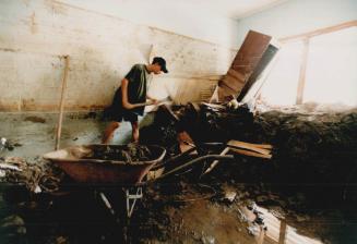 Muddy House. Cleaning his room. Ronald Carrillo has to use a pick axe, shovel and wheel barrow to clean a room in his house on the outskirts of La Cieba
