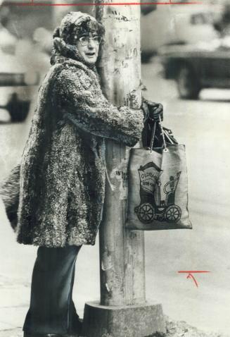 Terrified woman clings to a pole near Bay and Bloor Sts