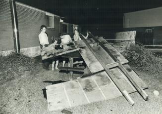Dale Andrews, (left), Michelle, 9, his wife, Mary Ann and Joann, 13, lift roof blown 150 yards
