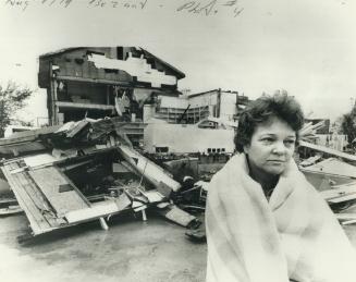 Mrs. Flossie Tanner and the gutted shell of her store and home in Oxford Centre