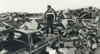 Ron McKittrick of Morrow Rd. in Barrie stands on hood of his truck as he surveys the rubble that was his ATLAS Auto Supply Company