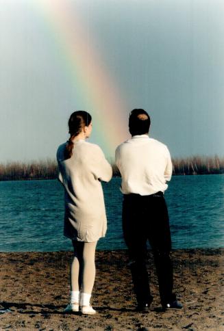 Calm after the storm: Monique Grignard and Mark Carpani gaze at a magnificent post-storm rainbow visible from Cherry Beach yesterday afternoon